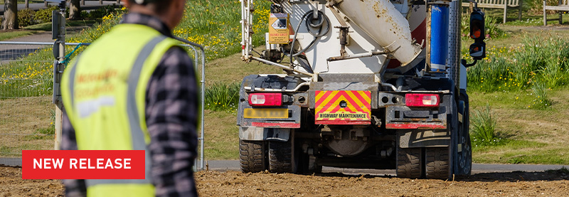 Be safer with HELLA Reversing Alarms New Release text over Image of reversing cement truck, with worker in foreground