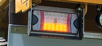 Close up Photo of HELLA Combi-SR Lamps on yellow dump truck