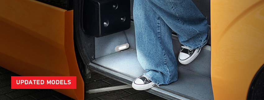 Young woman stepping off bus at night. Footwell illumintaed by light.