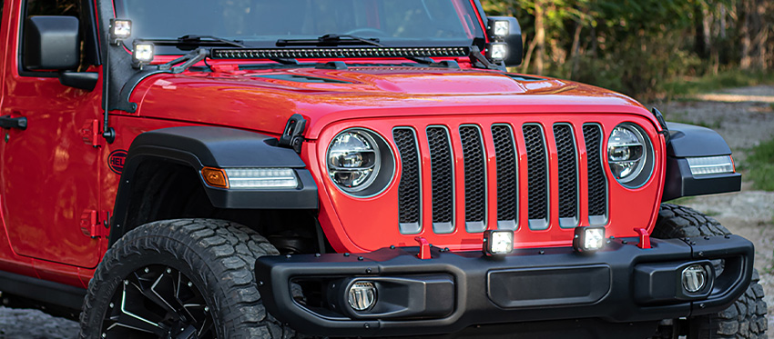 Black Magic Cube driving lights on bumper of Red Jeep Wrangler