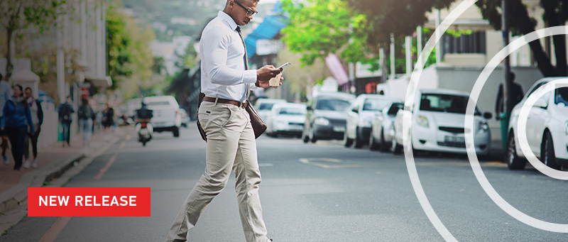 New Release text over image man walking in street looking at phone