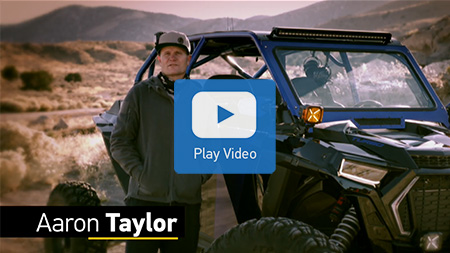 Man standing in front of off road vehicle in wilderness.